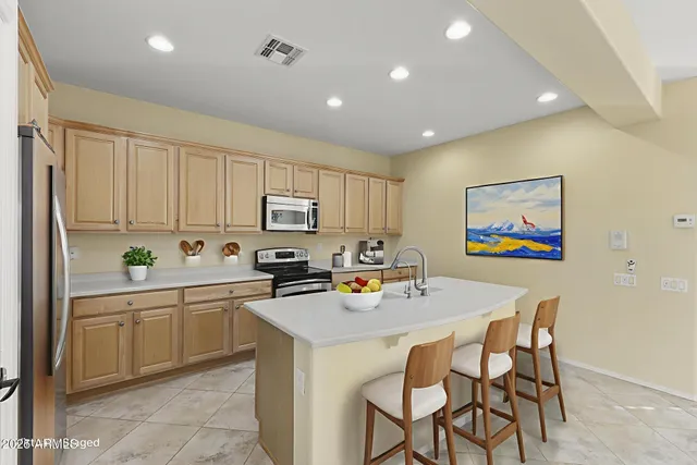 a kitchen with stainless steel appliances granite countertop a refrigerator a stove and a sink