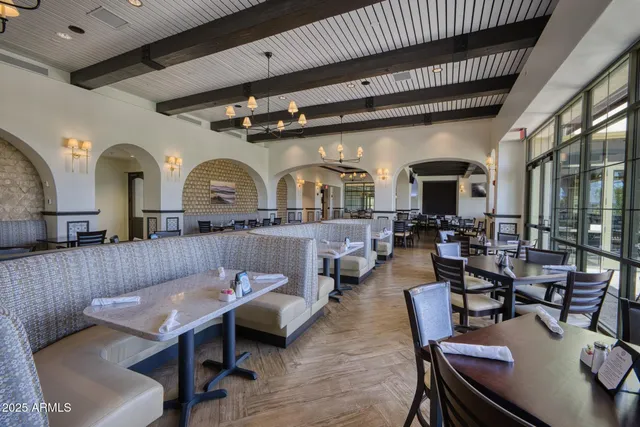 a kitchen with lots of wooden furniture dining table and chairs