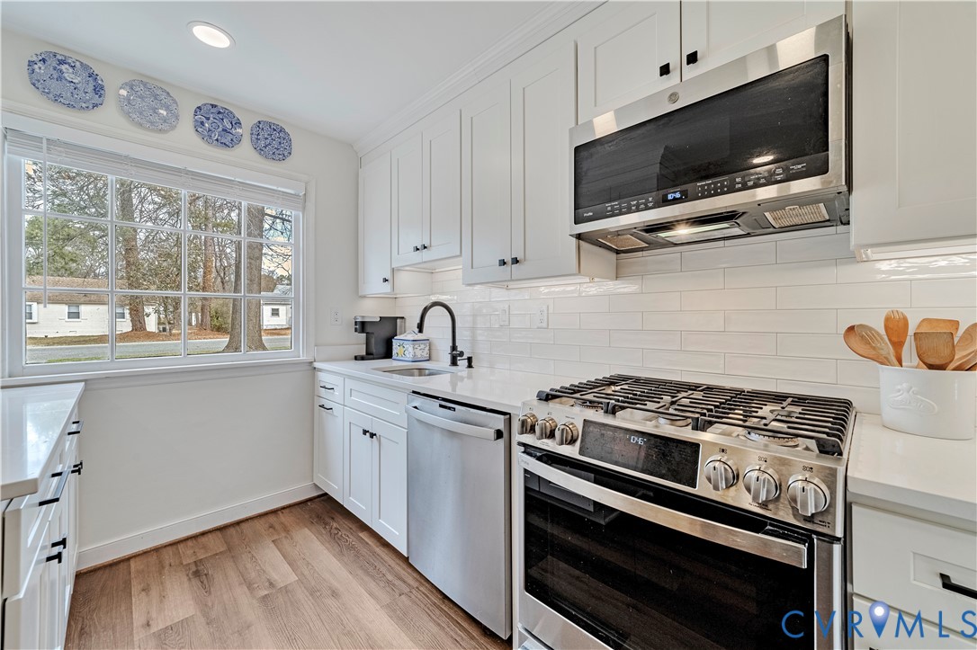 9111 Derbyshire Road, Unit G Henrico, VA 23229 - Photo 5 of 42 a kitchen with stainless steel appliances a stove a microwave and cabinets