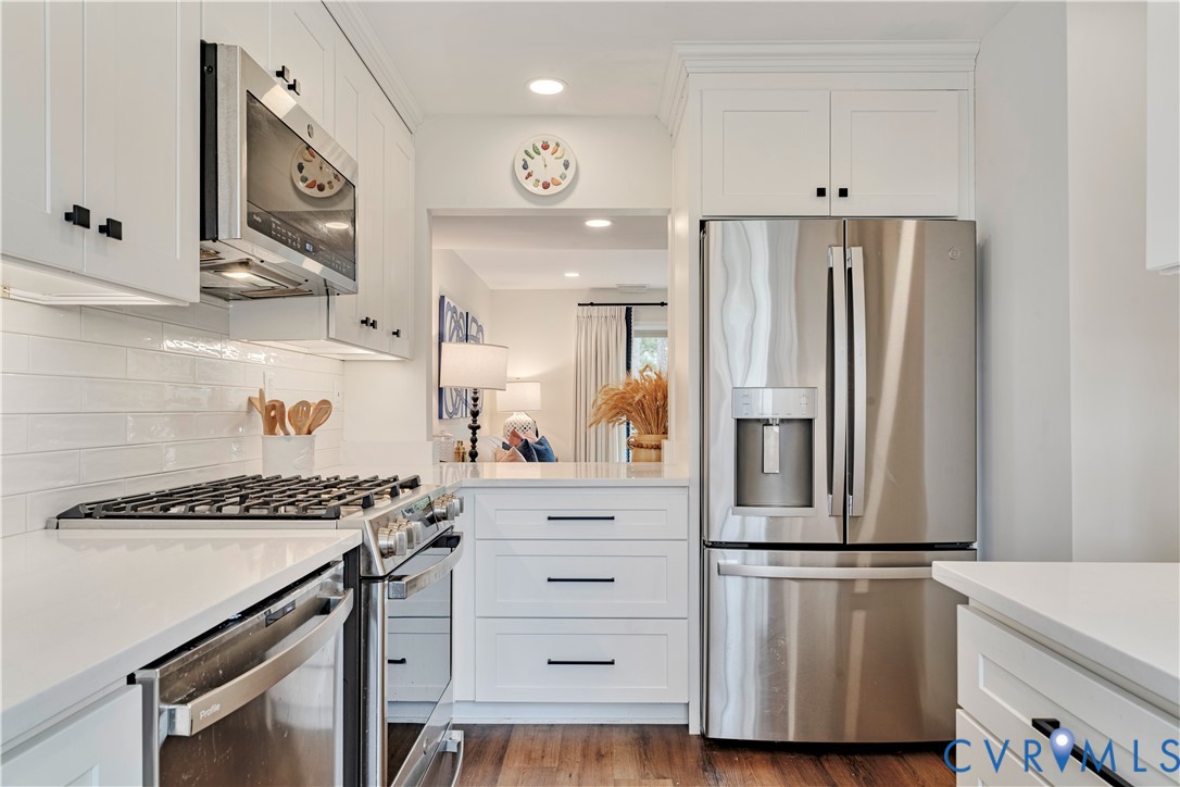 9111 Derbyshire Road, Unit G Henrico, VA 23229 - Photo 8 of 42 a kitchen with stainless steel appliances a refrigerator a stove and white cabinets