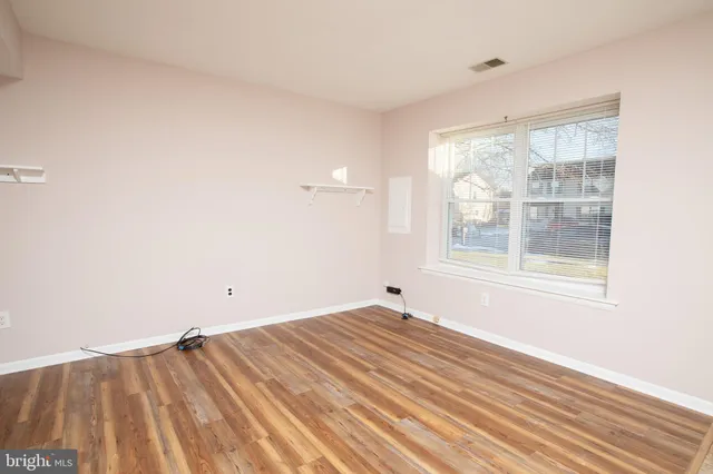 a view of a room with wooden floor and windows