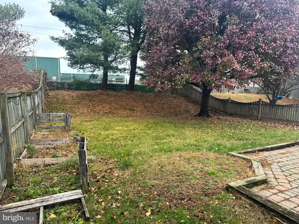 a view of a yard with wooden fence