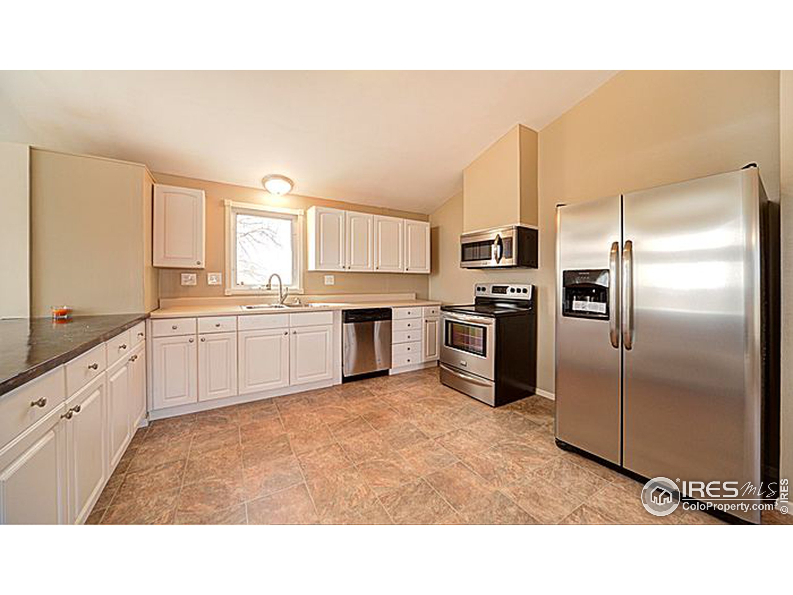 8966 County Road Hudson, CO 80642 - Photo 2 of 25 a kitchen with a refrigerator sink and cabinets
