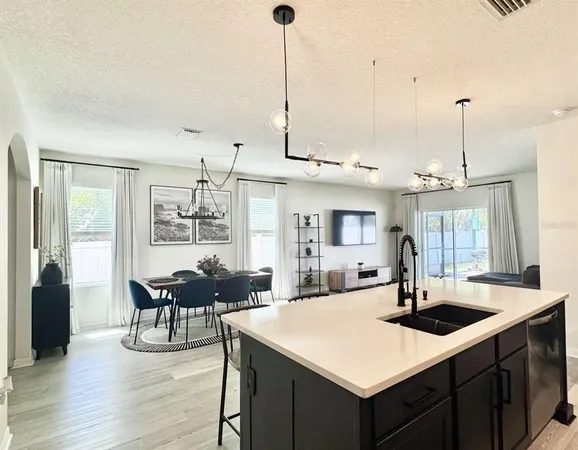 a kitchen with kitchen island a sink dining table and chairs