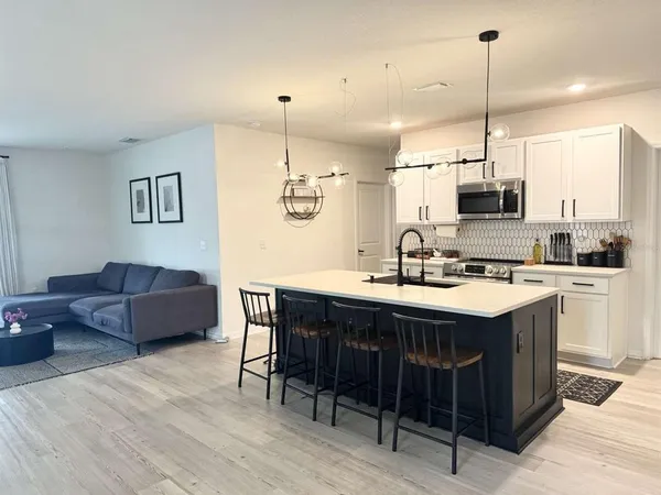 a kitchen island with stainless steel appliances kitchen island a sink and wooden floor