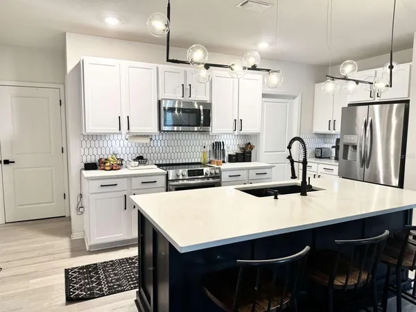 a kitchen with a sink a stove a refrigerator and cabinets