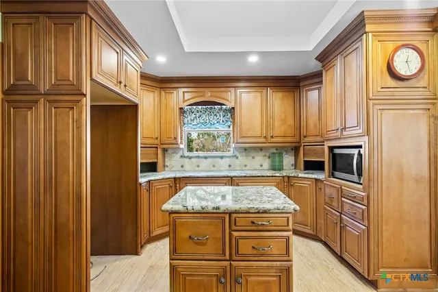 a view of an empty room with window and chandelier fan