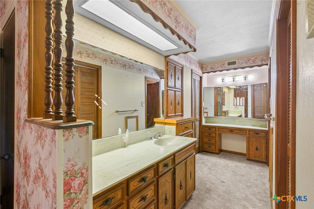 1101 Clark Street Yoakum, TX 77995 - Photo 18 of 48 a bathroom with a granite countertop sink and a mirror