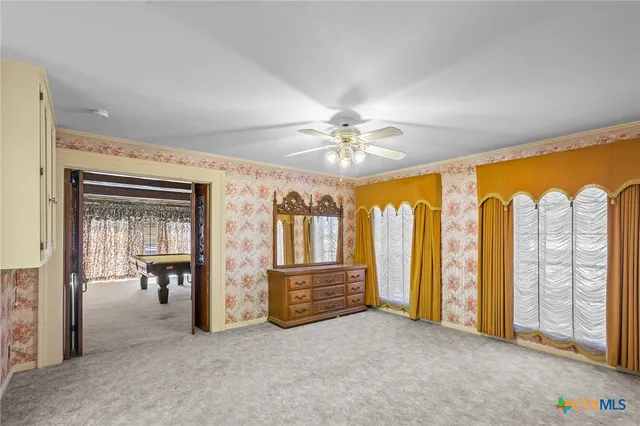 a room with pool table and windows