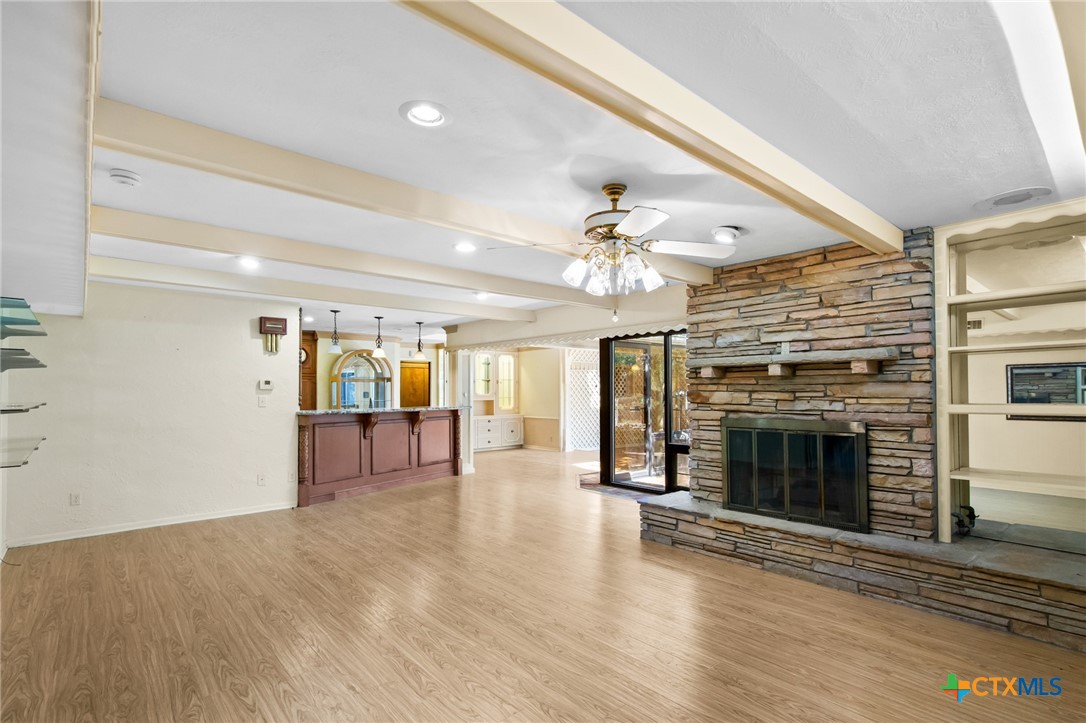 1101 Clark Street Yoakum, TX 77995 - Photo 7 of 48 an empty room with wooden floor fireplace and chandelier