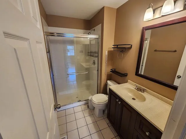 a bathroom with a granite countertop sink toilet and shower