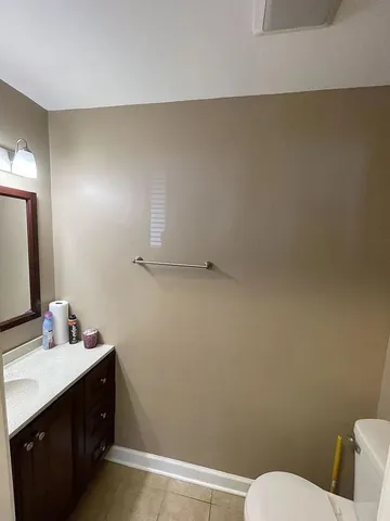 a bathroom with a sink vanity mirror and toilet