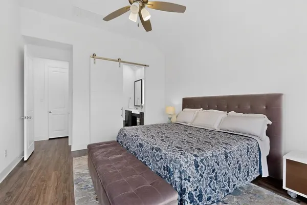 a bedroom with a large bed and a chandelier