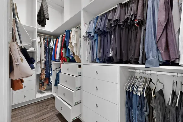 a view of walk in closet with clothes and shoes