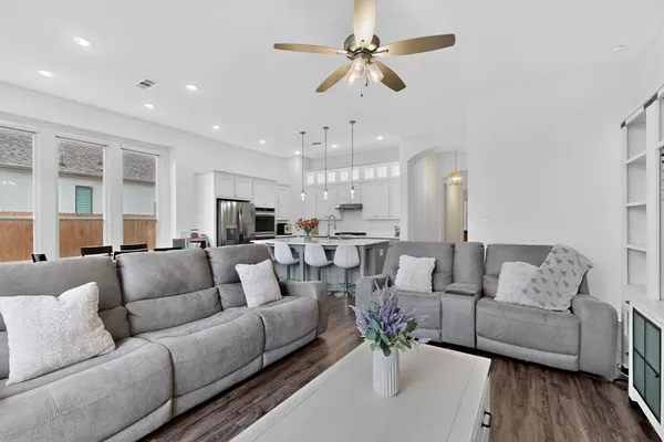 a living room with furniture kitchen view and a chandelier