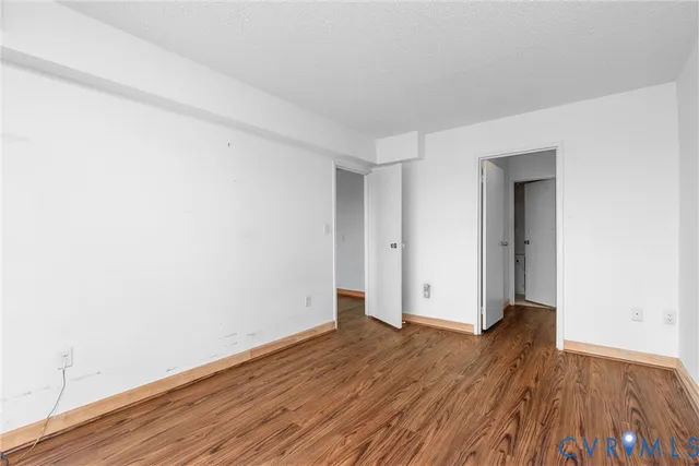 a view of an empty room with wooden floor