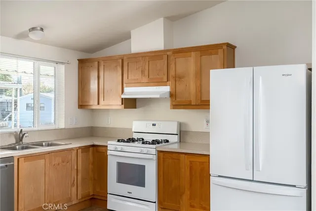 a kitchen with a sink a stove and a refrigerator