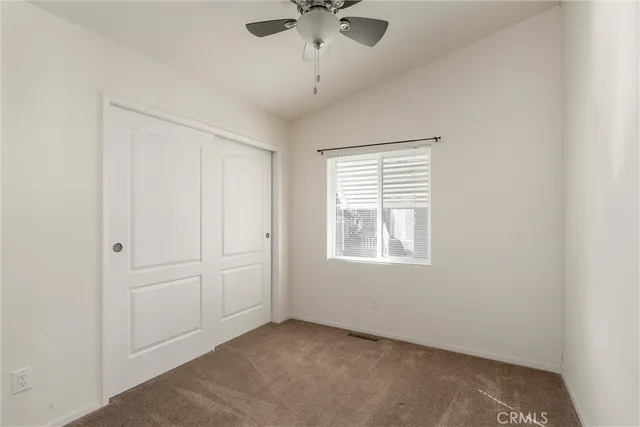 an empty room with a window and a ceiling fan
