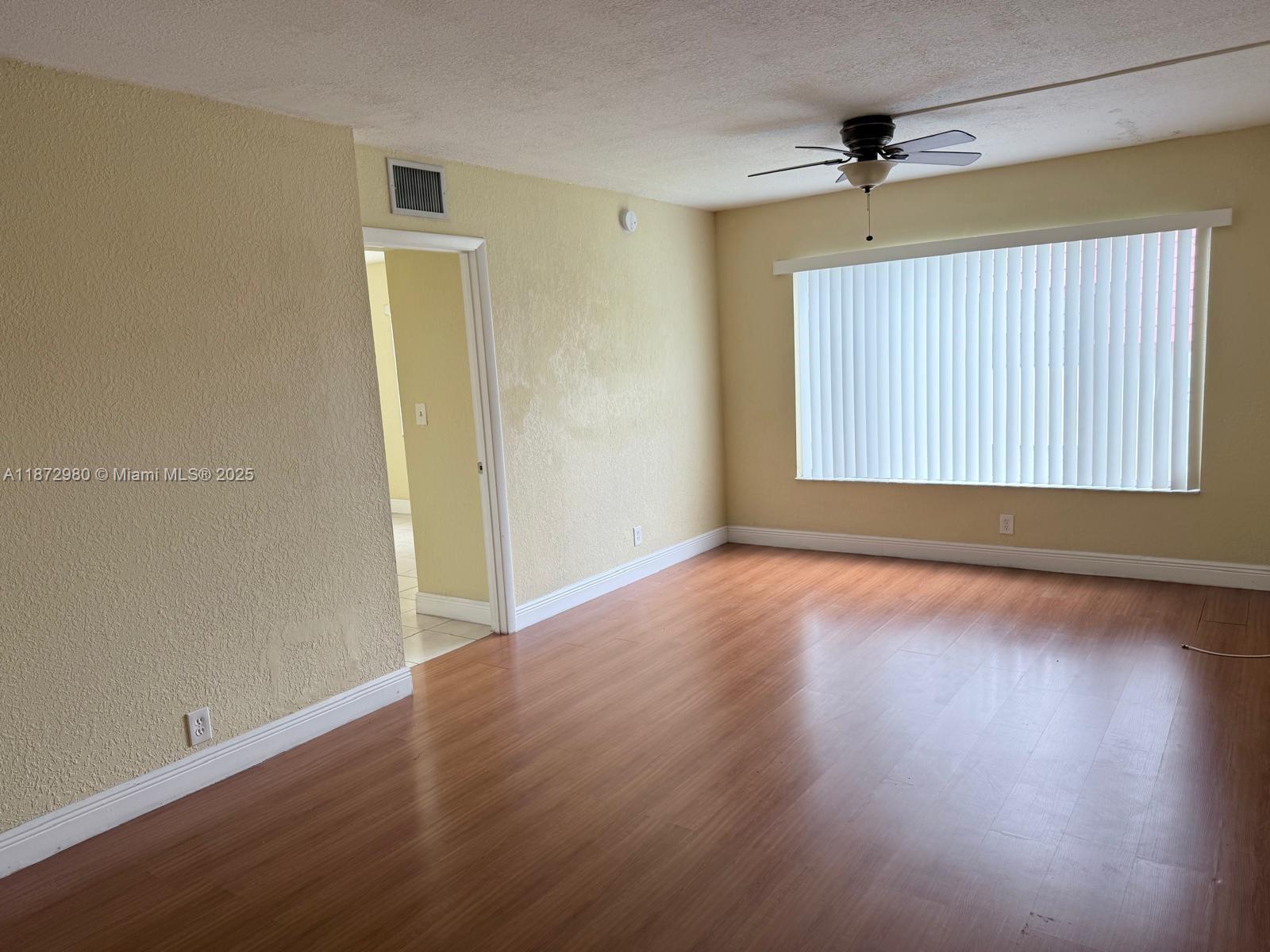 3224 Northwest 103rd Terrace, Unit 205B Coral Springs, FL 33065 - Photo 11 of 21 wooden floor in an empty room with a window