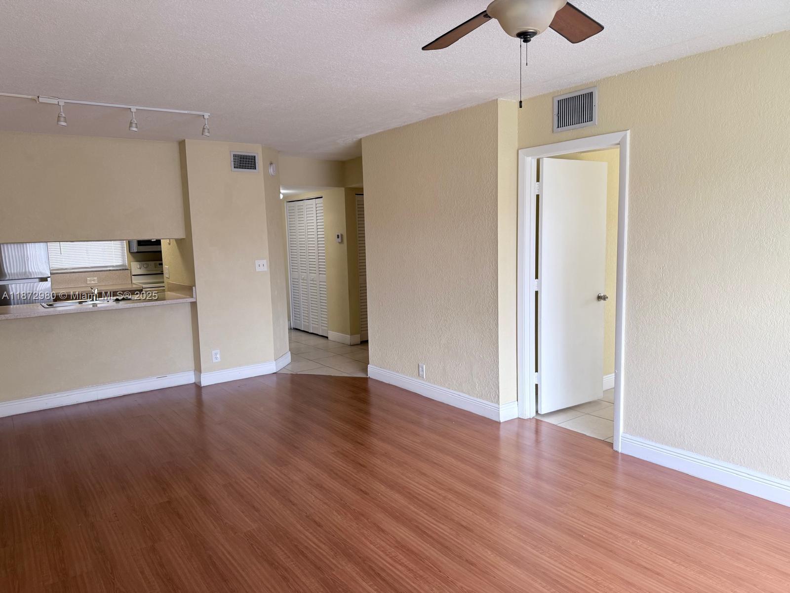 3224 Northwest 103rd Terrace, Unit 205B Coral Springs, FL 33065 - Photo 12 of 21 a view of a kitchen with wooden floor a sink and a refrigerator