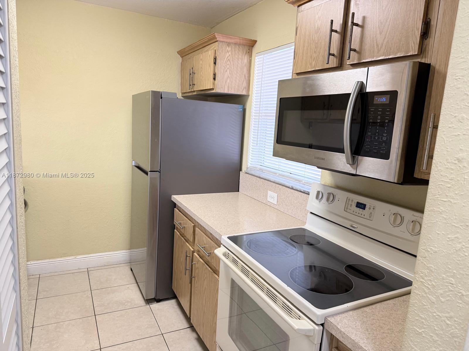3224 Northwest 103rd Terrace, Unit 205B Coral Springs, FL 33065 - Photo 19 of 21 a kitchen with a stove microwave and refrigerator