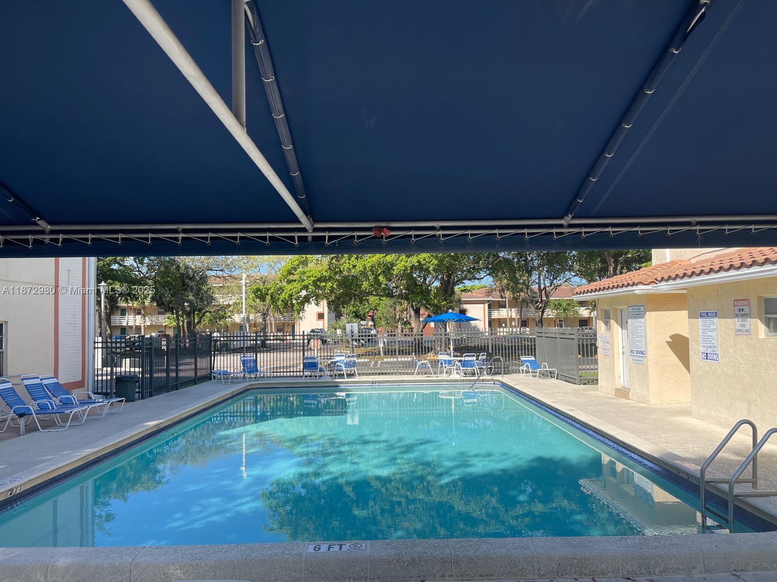 3224 Northwest 103rd Terrace, Unit 205B Coral Springs, FL 33065 - Photo 4 of 21 a backyard of a house with table and chairs