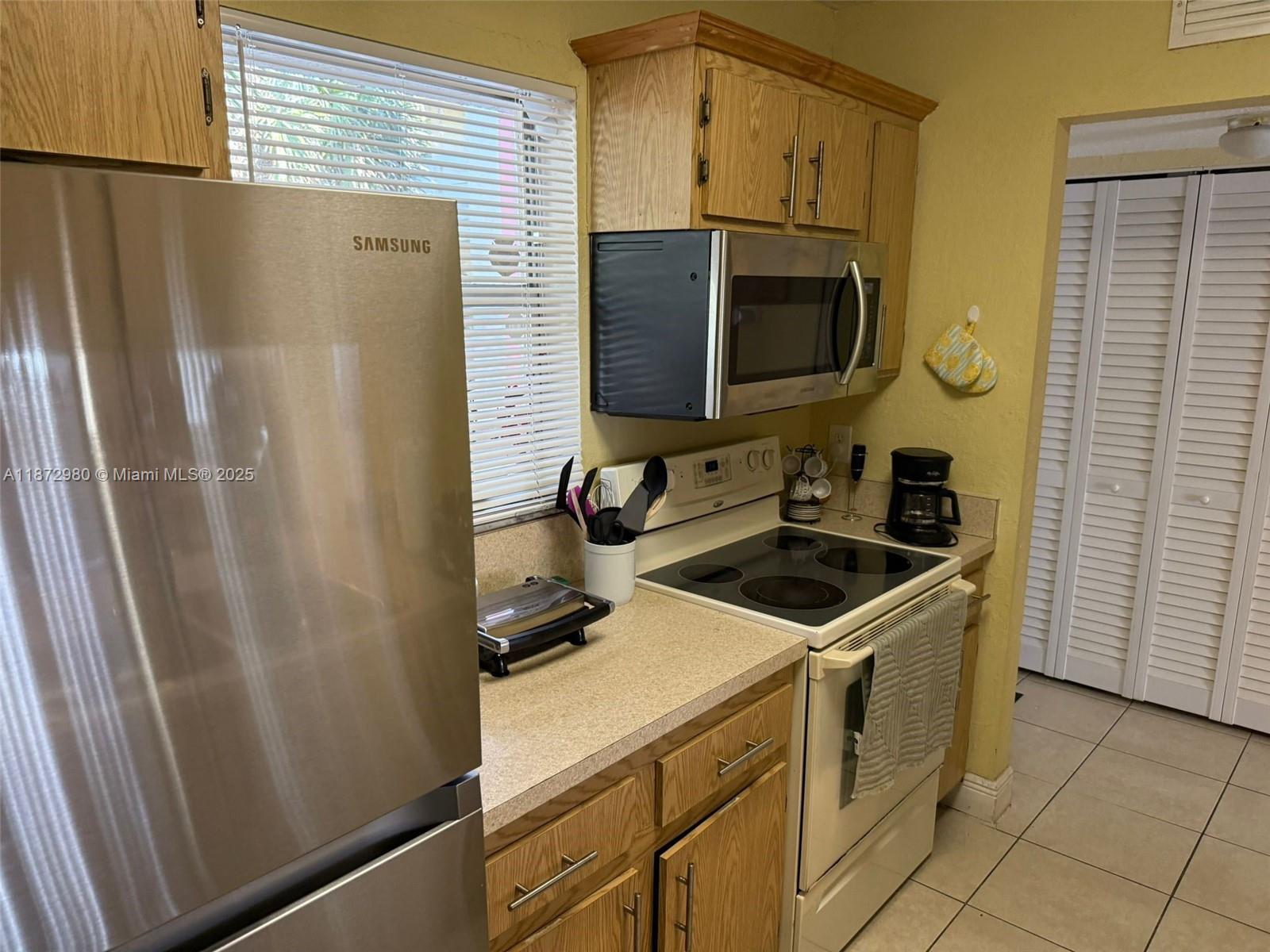 3224 Northwest 103rd Terrace, Unit 205B Coral Springs, FL 33065 - Photo 6 of 21 a kitchen with stainless steel appliances a refrigerator stove and microwave