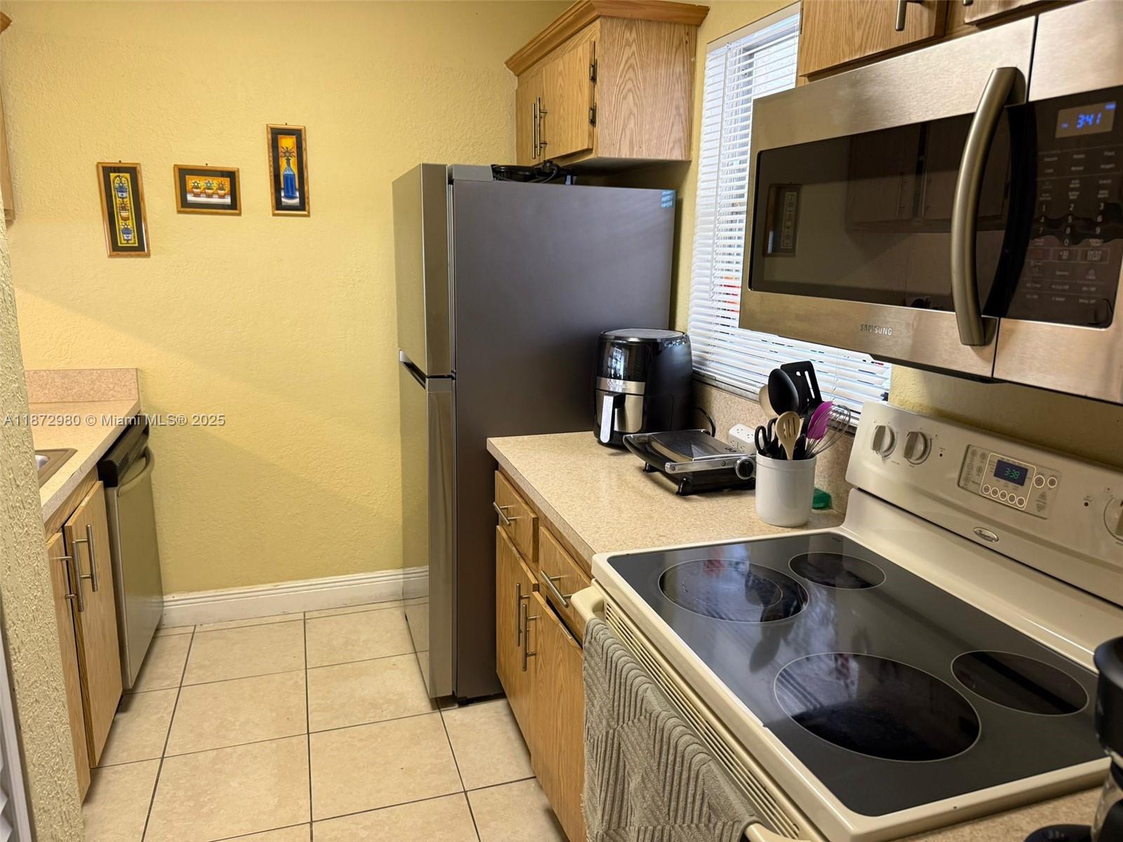 3224 Northwest 103rd Terrace, Unit 205B Coral Springs, FL 33065 - Photo 7 of 21 a kitchen with stainless steel appliances a stove microwave and refrigerator