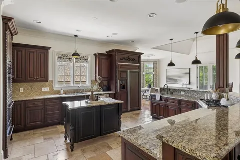 a kitchen with stainless steel appliances granite countertop a sink counter space cabinets and a large window