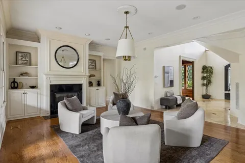 a living room with furniture a large window and a fireplace