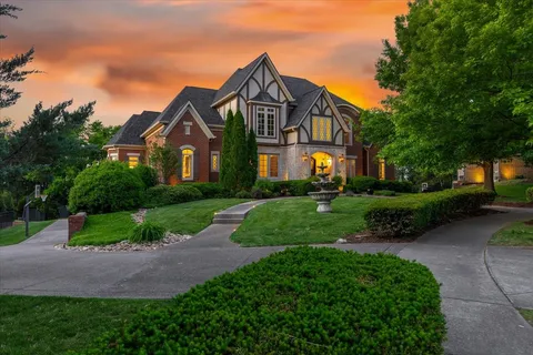 a front view of a house with a yard and green space