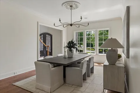 a dining room with furniture a chandelier and window