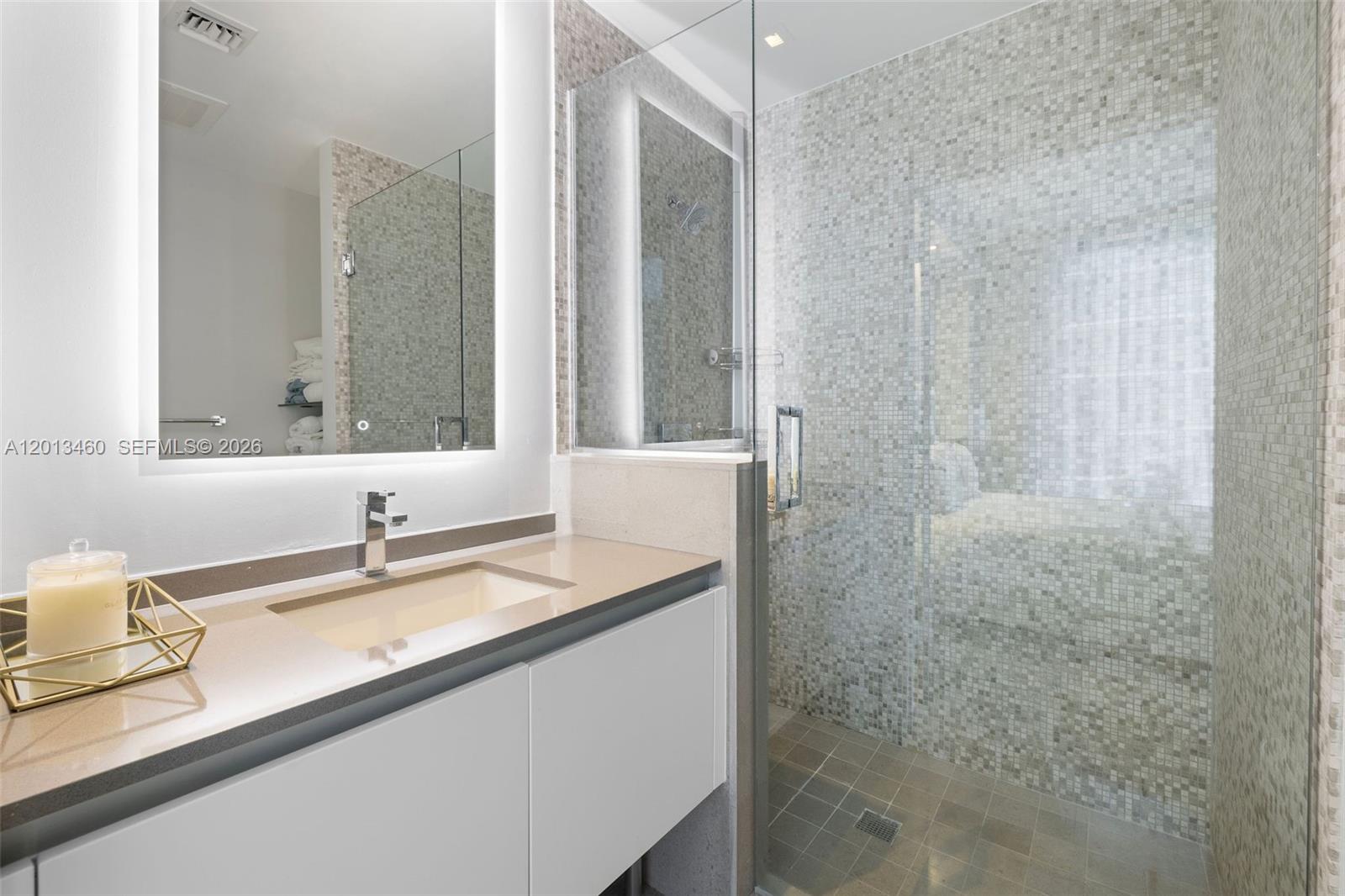 88 Southwest 7th Street, Unit 1201 Miami, FL 33130 - Photo 12 of 39 a bathroom with a sink and a mirror