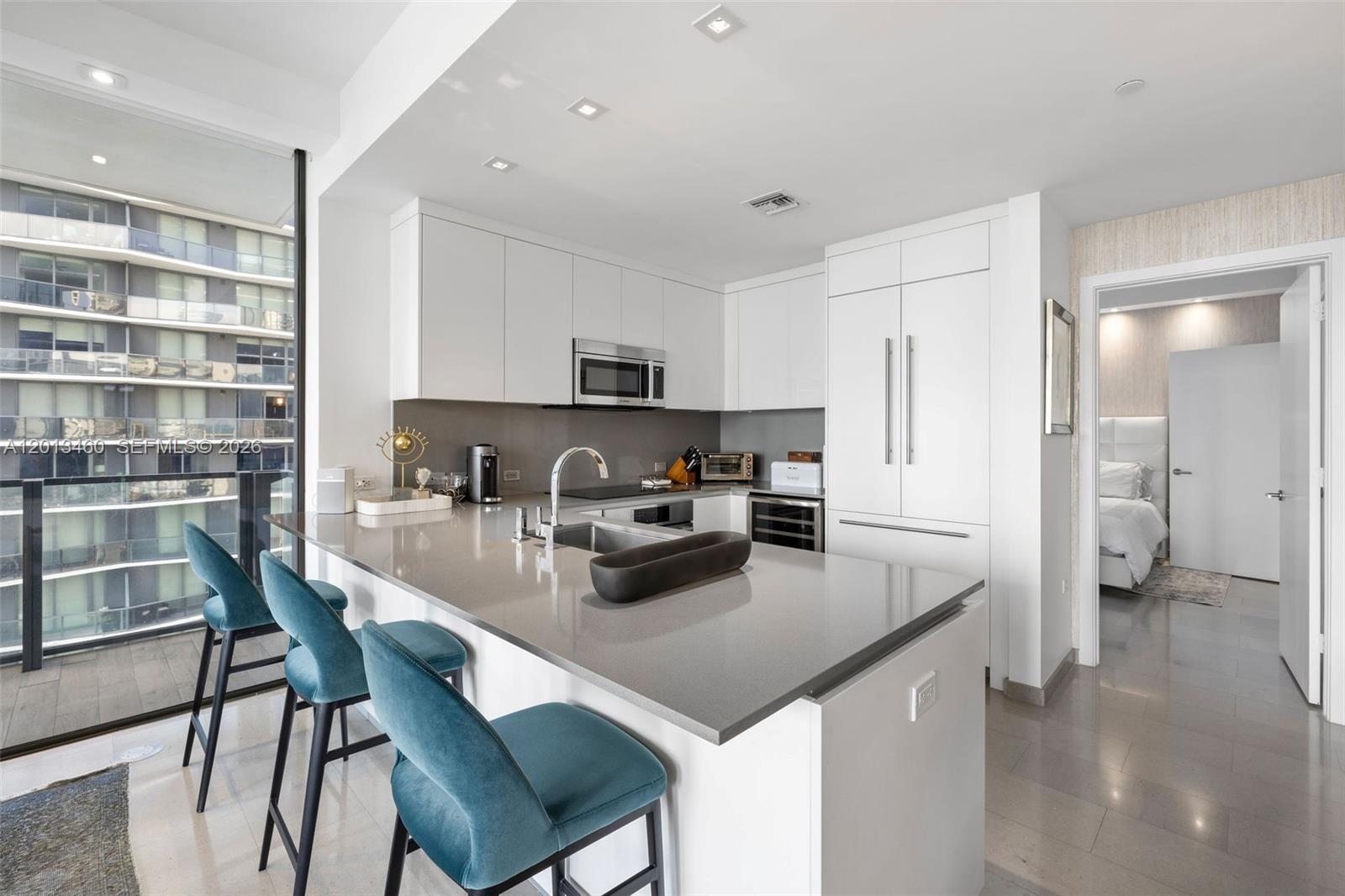 88 Southwest 7th Street, Unit 1201 Miami, FL 33130 - Photo 19 of 39 a kitchen with stainless steel appliances granite countertop a stove a refrigerator a sink a table and chairs