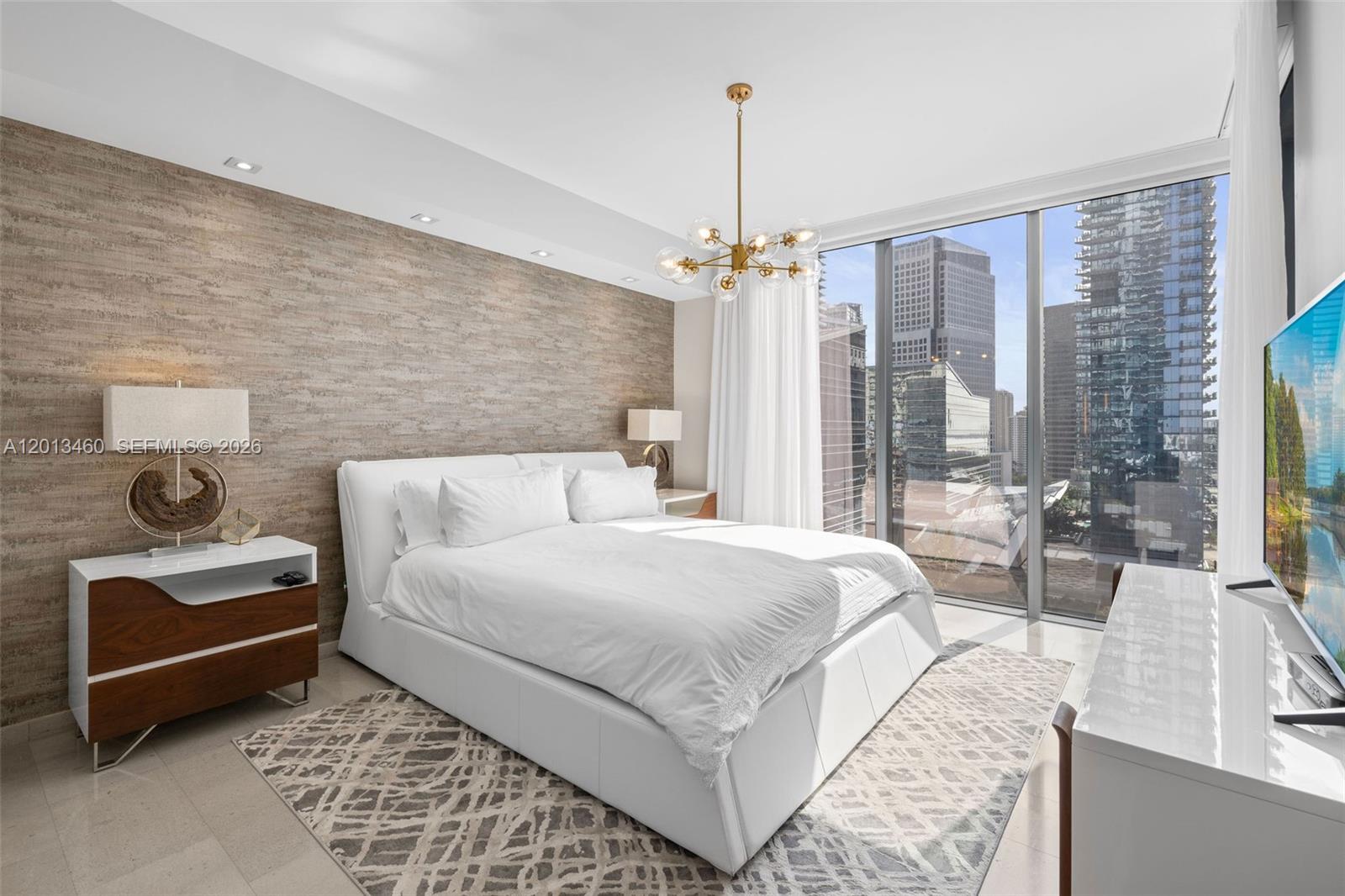 88 Southwest 7th Street, Unit 1201 Miami, FL 33130 - Photo 28 of 39 a bedroom with a bed lamps and table
