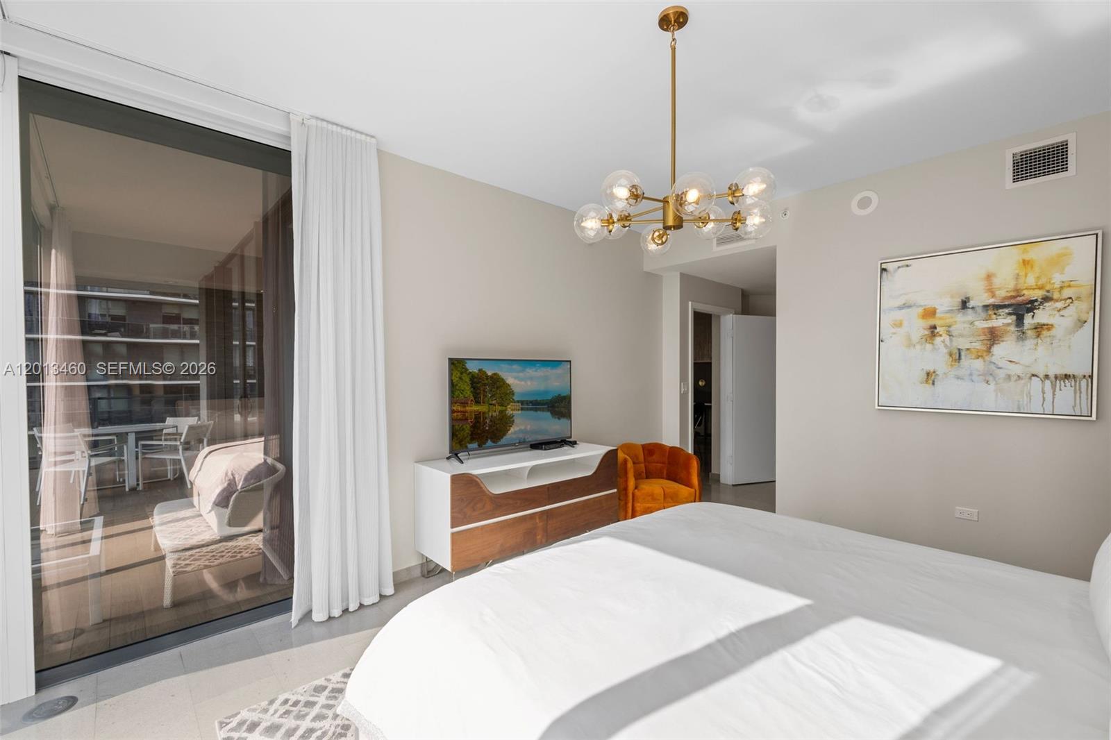 88 Southwest 7th Street, Unit 1201 Miami, FL 33130 - Photo 29 of 39 a bedroom with a bed chandelier and a window