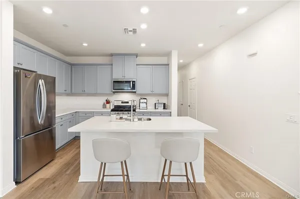 a kitchen with kitchen island a appliances dining table and chairs