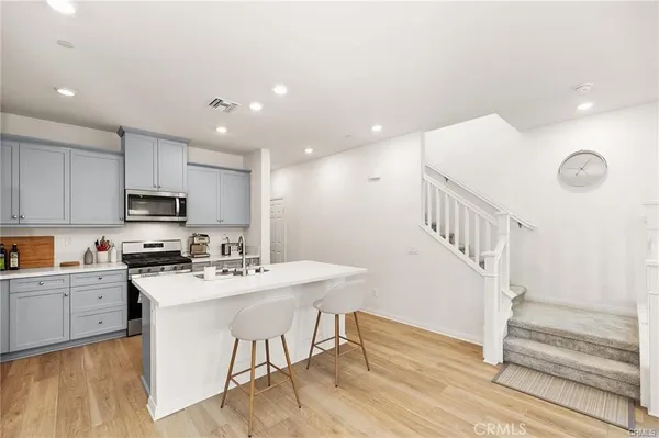 a kitchen with a sink a microwave and wooden floor