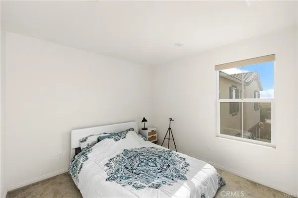 a bed sitting in a bedroom next to a window
