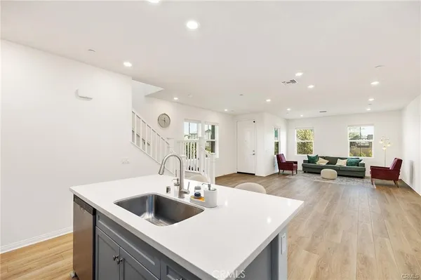 a view of a kitchen counter top space with sink and living room