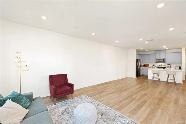 a spacious bedroom with a bed a couch and a potted plant