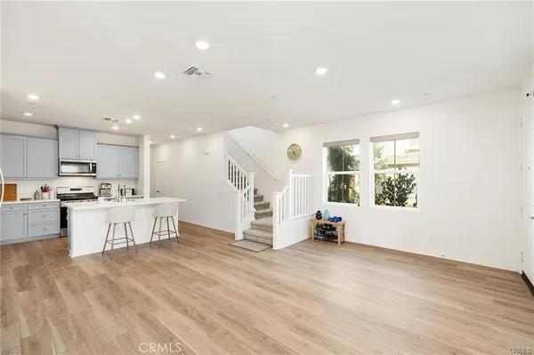 a view of kitchen with kitchen island white cabinets and wooden floor