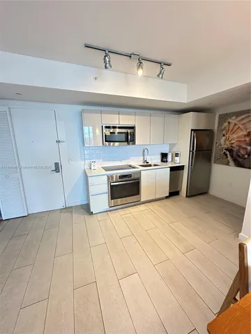 a large kitchen with cabinets and stainless steel appliances