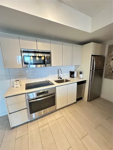 a kitchen with stainless steel appliances granite countertop a stove a sink and a refrigerator