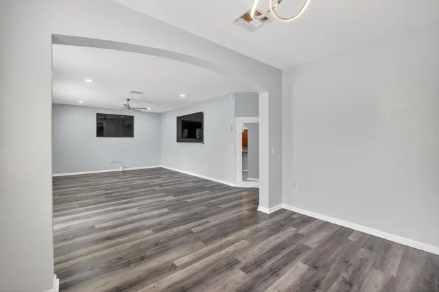 a spacious bedroom with a bed and a flat screen tv