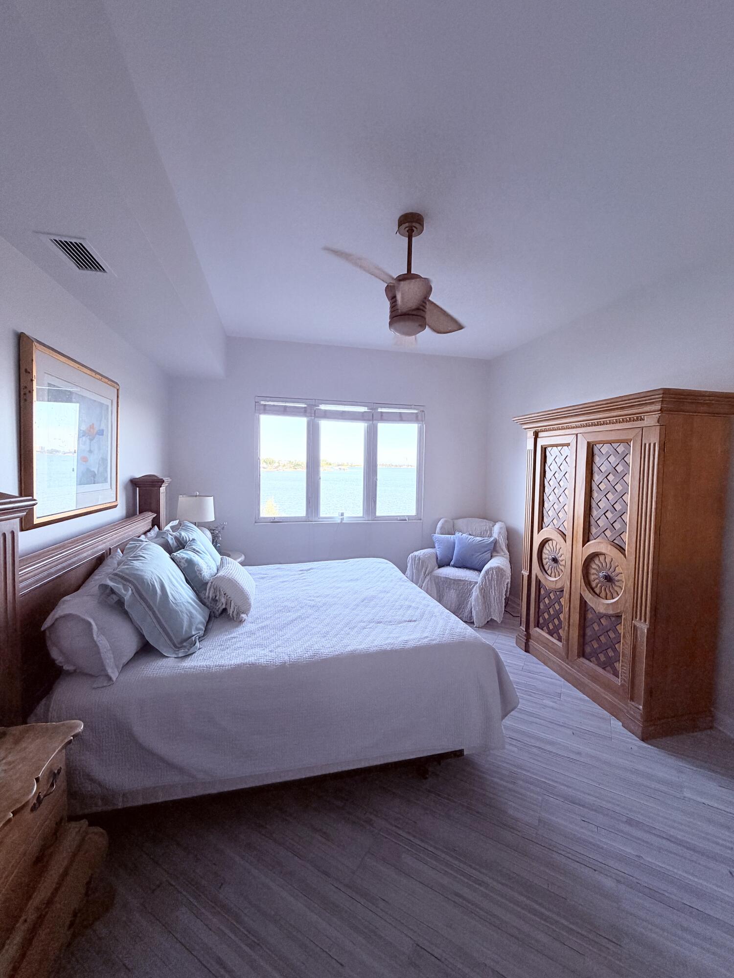 3 Harbour Isle Drive East, Unit 204 Fort Pierce, FL 34949 - Photo 11 of 21 a bedroom with a bed and a chandelier