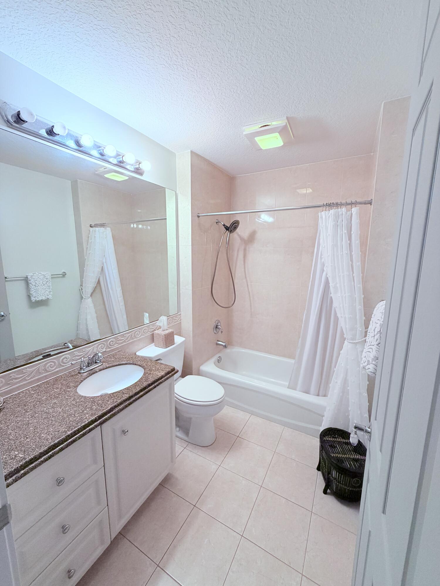 3 Harbour Isle Drive East, Unit 204 Fort Pierce, FL 34949 - Photo 16 of 21 a bathroom with a granite countertop sink a toilet and a mirror