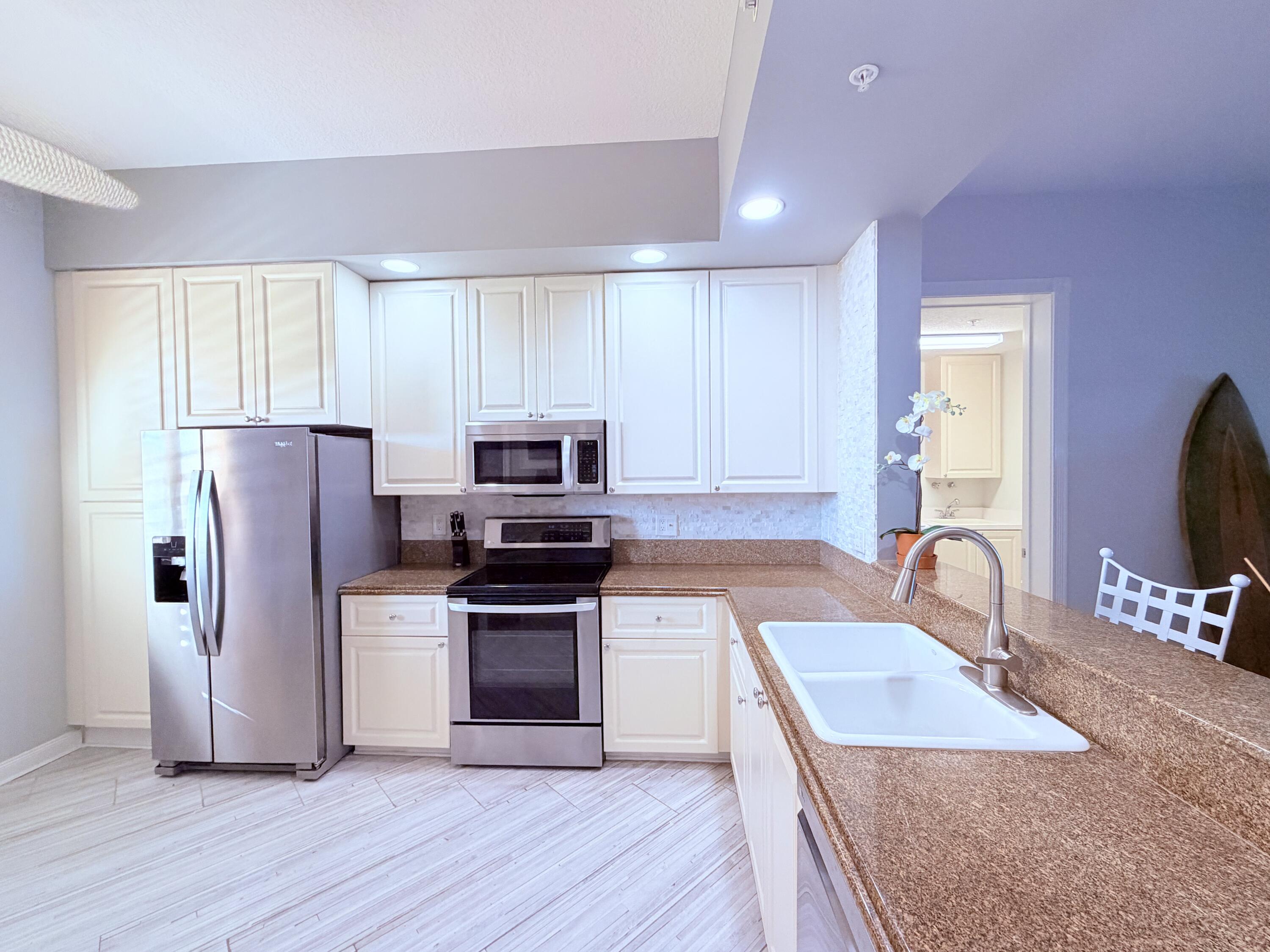 3 Harbour Isle Drive East, Unit 204 Fort Pierce, FL 34949 - Photo 17 of 21 a kitchen with granite countertop a refrigerator stove and sink