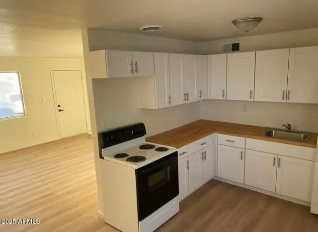 a kitchen with granite countertop white cabinets and white appliances