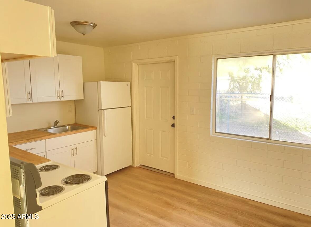 704 West 11th Street Casa Grande, AZ 85122 - Photo 3 of 10 a kitchen with a refrigerator a stove cabinets and wooden floor